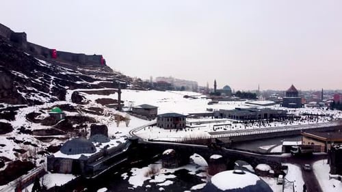 Aerial View of Kars Castle and Historical Stone Bridge Covered in Winter Snow, Turkey