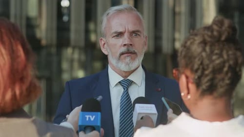 Man in Suit Answers Reporters Questions