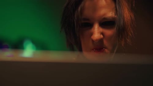 Erschöpfte Hackerin oder Programmiererin, die im Nachtporträt mit dem Computer arbeitet, Cyberkriminalität und