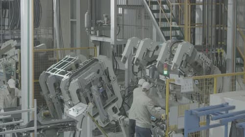 Industriearbeiter in Uniform drückt ein Bauteil aus Stahlblech unter Druck