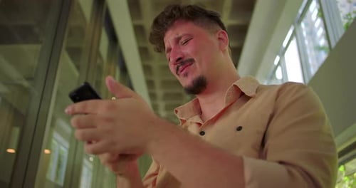 Frustrated Man Using Smartphone in Urban Setting
