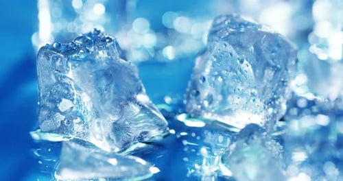 Macro shot of pure water ice cubes that melt in slow motion on a blue background. Concept: pure mo