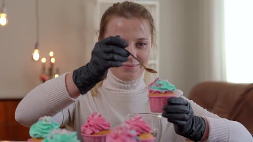 Woman Decorating Cupcakes with Frosting and Sprinkles