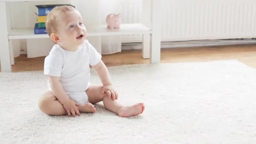 Childhood, Babyhood And People Concept - Happy Little Baby Crawling To Sofa And Getting Up In Liv...