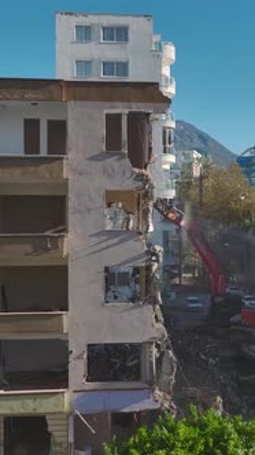 Vertical Video Hydraulic Power Demolishes an Old Building As an Excavator Tears Apart Walls and
