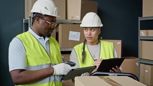 Diverse Warehouse Workers Checking Inventory with Tablet and Clipboard