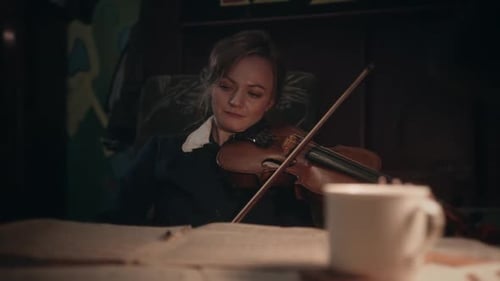 Woman Playing Violin with Sheet Music Indoors
