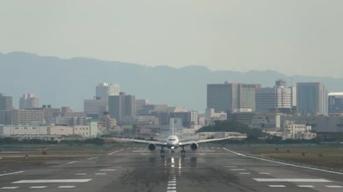 Eine Frontalaufnahme einer Landebahn eines Flughafens mit einem Flugzeug, das landet und auf die Kamera zufährt
