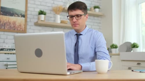 Man Working from Home on Laptop Computer