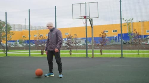 Older Man Practicing Basketball on Urban Outdoor Court at Daytime An Experienced Mature Man