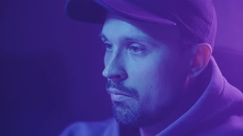 a man in a cap looks at a close-up of a computer screen1