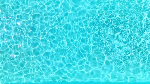 Blaues Wasser im Schwimmbad mit Lichtreflexen in Zeitlupe