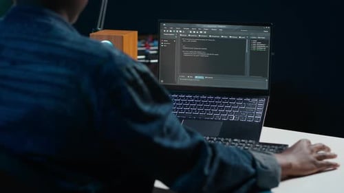 Softwareentwickler schreibt Code auf den Laptop-Bildschirm, während er im Büro einer Wohnung ist