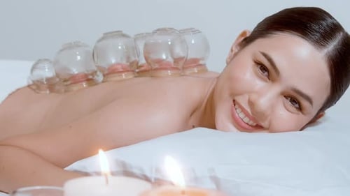 Woman Receiving Cupping Therapy with Lit Candles
