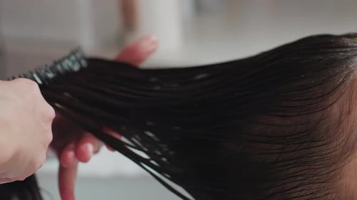 Woman Gets Her Long Dark Hair Combed at Salon