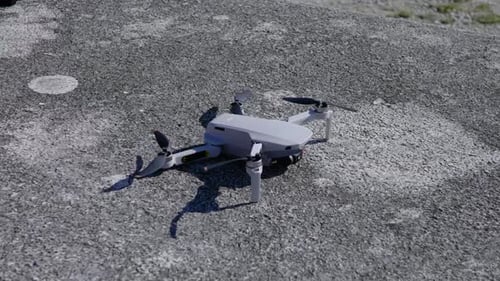 Drone DJI Mini 2 taking off on a rock table, hovering in the wind, flying drone