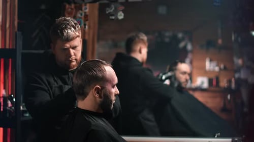 Man Getting Haircut in a Dark Barber Shop