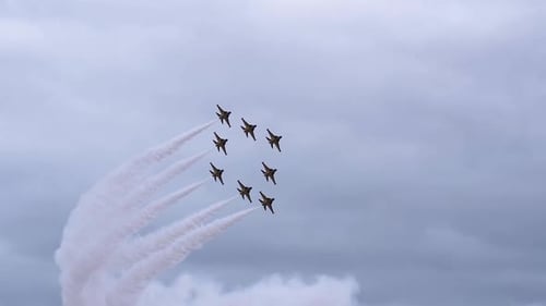 KAI T-50B Fighter Jets Soaring In Perfect Unison, Leaving Smoke Trail Against Cloudy Sky. low angle,