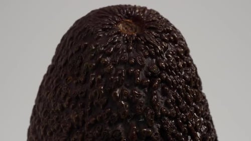 Reife Avocado rotiert auf weißem Hintergrund