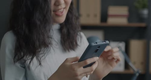 Smiling Woman Using Smartphone Indoors