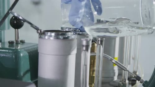 Una mano vierte agua en un moderno equipo de examen