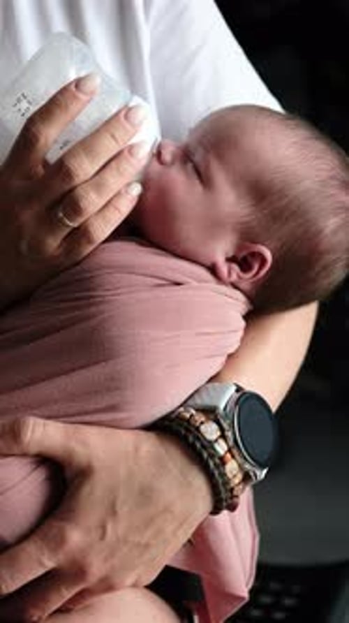 Woman Feeds Newborn Baby with Bottle