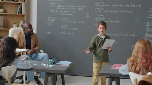 Boy Making Report in front of Class in School