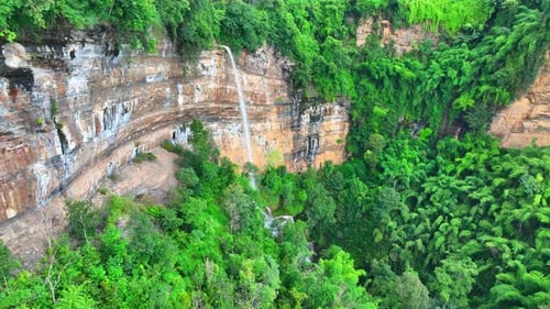 Drone captures stunning cliff waterfall.