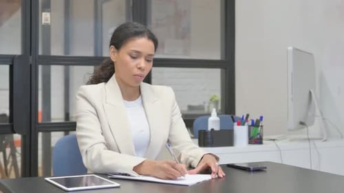 African Business Woman Writing a Letter in Office