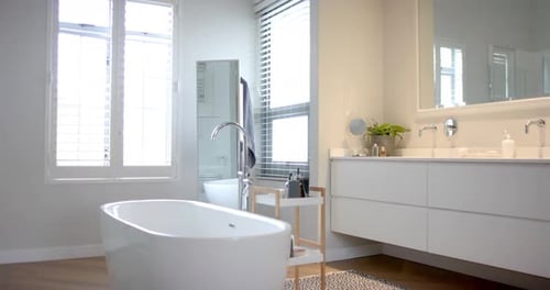 Close up of sunny white bathroom with freestanding bathtub, slow motion