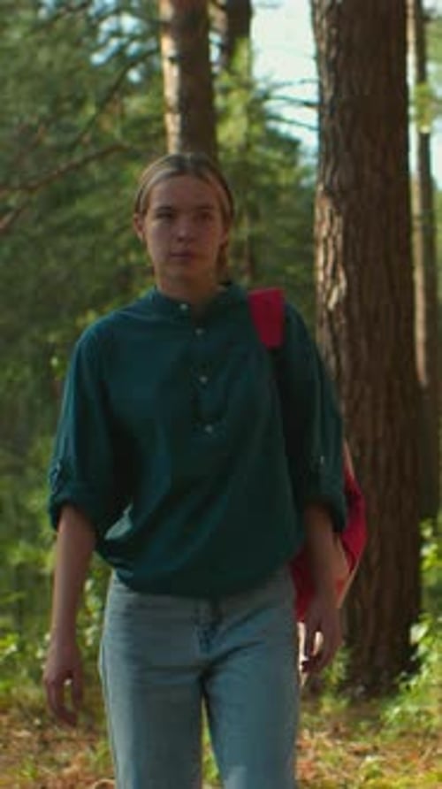 Hikers Walking Through Sunlit Forest with Backpack and Headscarf