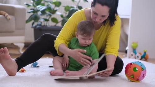 Mother and Baby Reading a Book Indoors