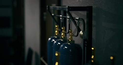 Industrial Gas Cylinders Organized on Metal Rack in a Workshop Area