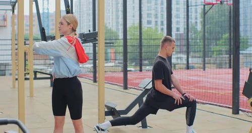 Woman and Man Stretching on Outdoor Workout Area