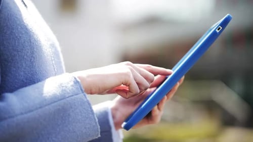 Young businesswoman using tablet pc computer outdoors in the city