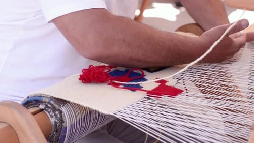 Adult Weaving Colorful Rug on Loom