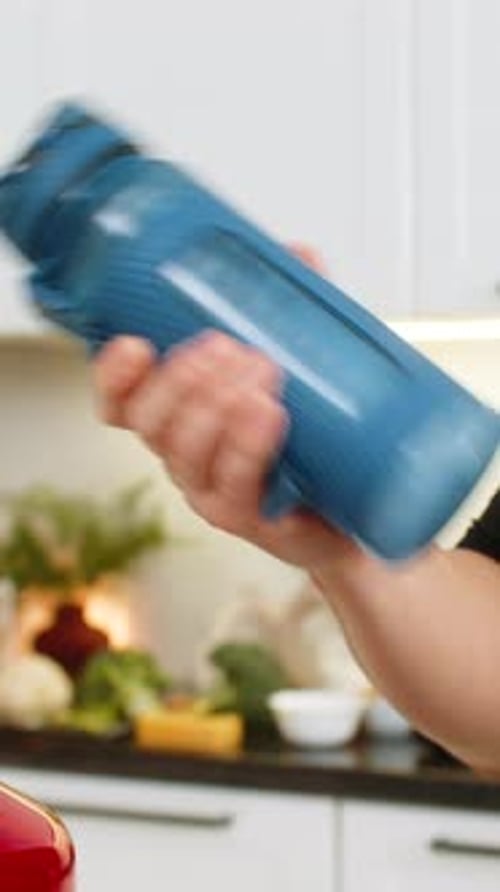 Man Shaking Shaker Bottle in Kitchen Mixing Sports Supplement Drink Electrolyte Creatine Protein Gym
