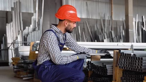 Der Fabrikarbeiter überprüft die Qualität des Metallprofils