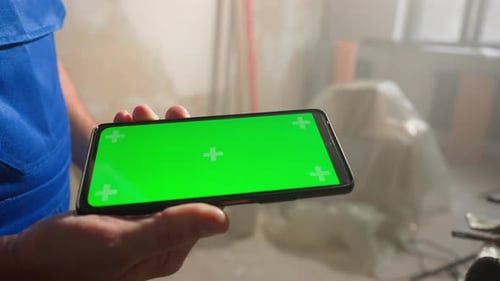 Male Builder Holding Touch Screen Smartphone with Green Screen Chroma Key