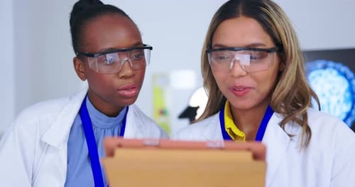 Scientists Discussing Data on Tablet in Lab