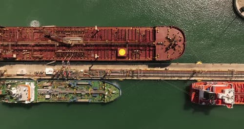 Oil tankers unloading crude oil in a port terminal.