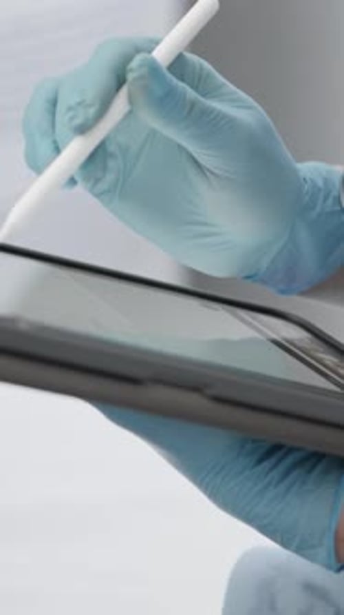 Doctor Using Tablet with Stylus in Hospital Setting