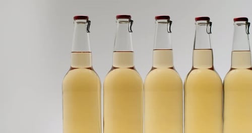 Line of Glass Bottles with Red Lids Panning Shot