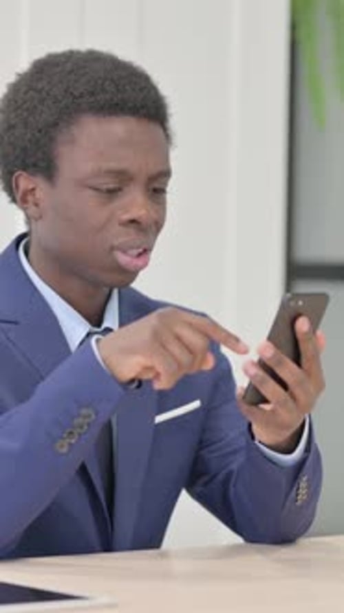 African Businessman Reacting to Loss on Smartphone, Vertical Video