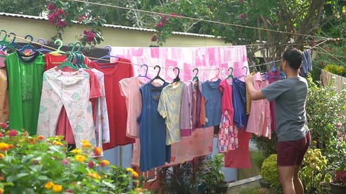 Filipina Lady Doing Household Chores and Drying the Hanging Laundry Clothes at the Orphanage Home in