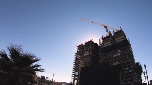 Una grúa vacila mientras espera para transportar materiales de un lado a otro de la construcción.