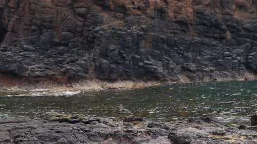 Ocean Waves Crashing on Black Rocky Shoreline