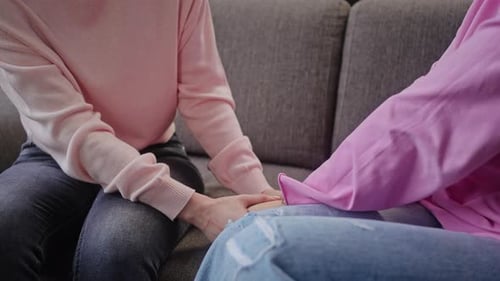 Friends Sitting Together Holding Hands on Sofa