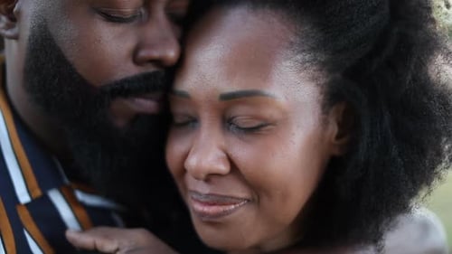 African couple together in romance outside at park. beautiful black man and woman embrace