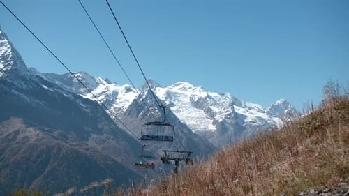 Cable Car Moving Up Snowy Mountain Slope on Sunny Day
